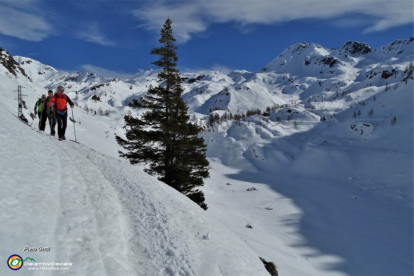 54 In cammino sulla traccia scavata nella neve sul ripido pendio dell'invaso del lago ...senz'acqua, bianco di neve con vista sul Madonnino.JPG